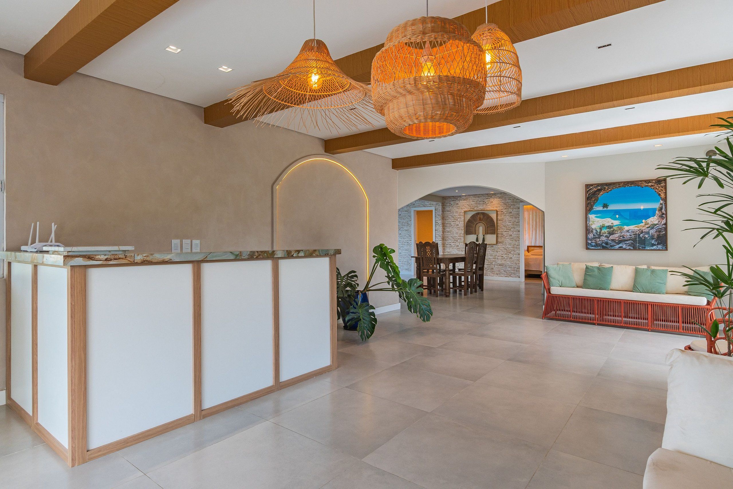 A spacious lobby with a reception desk, a dining area, and a seating area with a view of the ocean.