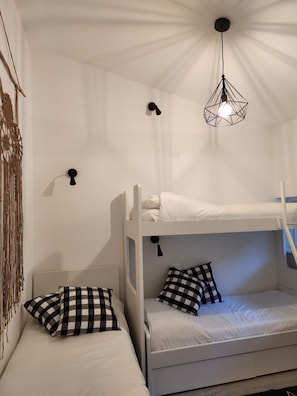 A bunk bed room with a hanging light fixture and wall-mounted lamps. - Vrbo Property (Lombardia)