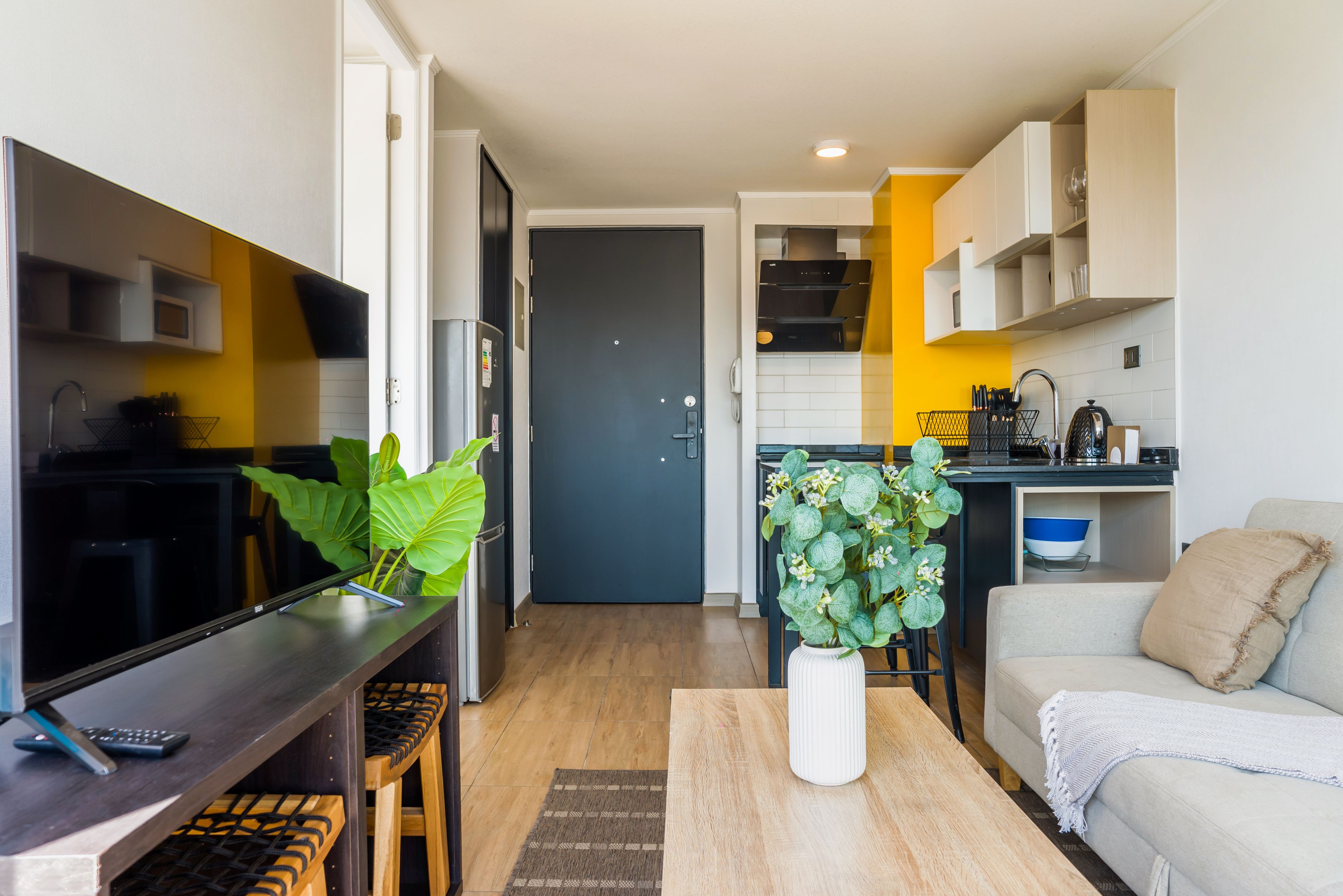 A compact living space with a kitchenette, a dining area, and a seating area with a sofa.