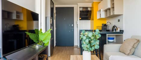 A compact living space with a kitchenette, a dining area, and a seating area with a sofa.