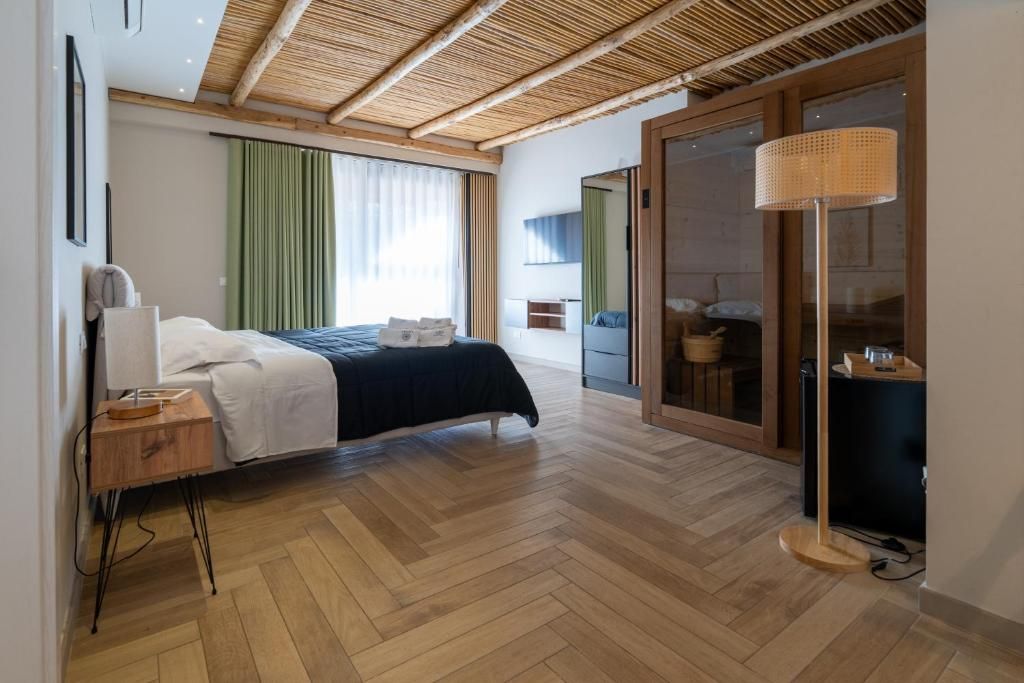 Un dormitorio moderno con cama, mesita de noche, lámpara y puerta corrediza de vidrio que da a un balcón.