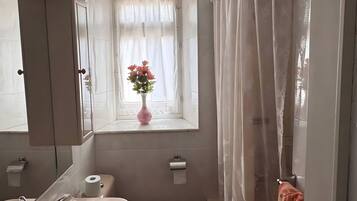 Een badkamer met toilet, wastafel en douchegordijn.
