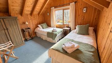 Une chambre confortable avec deux lits, un bureau et une chaise.