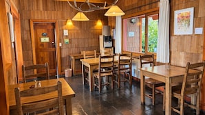 Un interno in legno con tavoli e sedie, una macchina da caffè e una porta con un cartello.