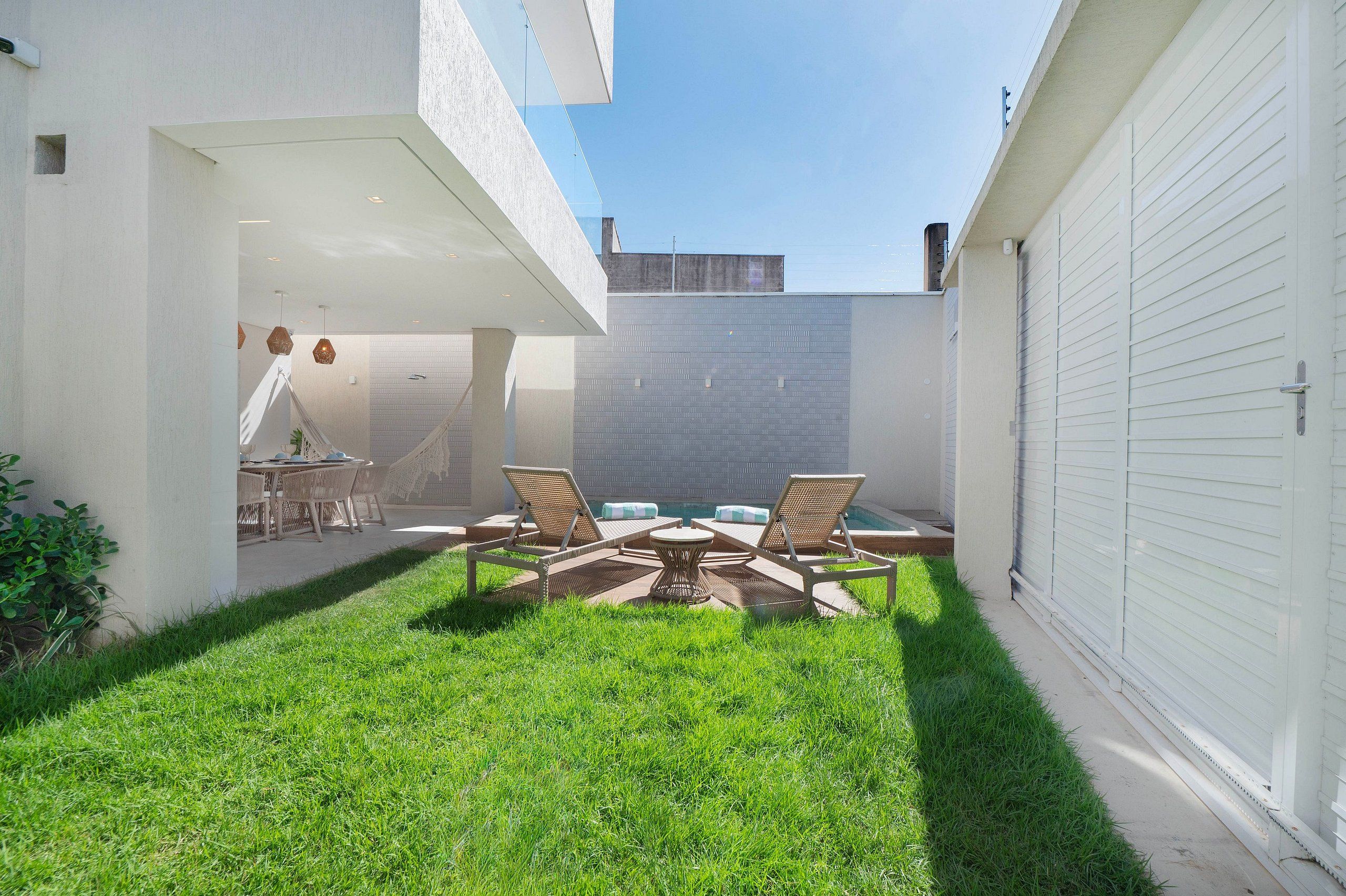 Een moderne buitenpatio met een eethoek en lounge fauteuils.