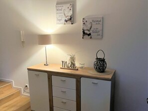 A room with a desk, a lamp, a small plant, a candle, and wall art. - 49.0.s Waterkant (Wangerland)