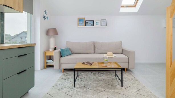 Una sala de estar moderna con sofá, mesa de centro y tragaluz.
