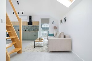 A modern interior with a staircase, kitchen, living area, and a view through an open door. - Rusinowo | Bosmańska 2 | Cosy Apartment | Balcony | Close to the sea (Rusinowo)