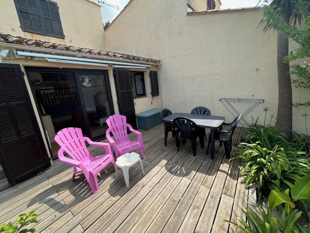 A wooden deck with outdoor furniture, including chairs and a table.