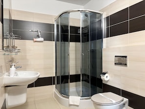 A modern bathroom with a glass-enclosed shower, a white sink, and a toilet. - MARGI City 4 Apartament (Szczecin)