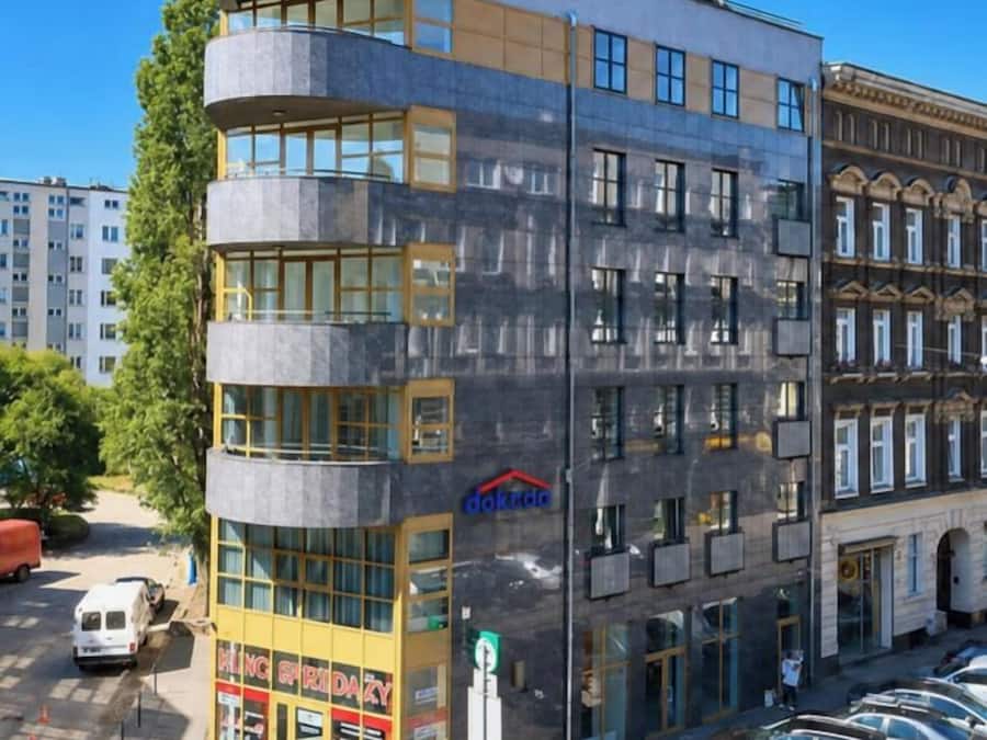 A multi-story building with a modern design, featuring a ground-level commercial space with a visible storefront.