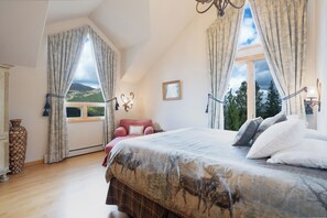 Une chambre à coucher avec un grand lit, une chaise, une commode et une fenêtre donnant sur l’extérieur.