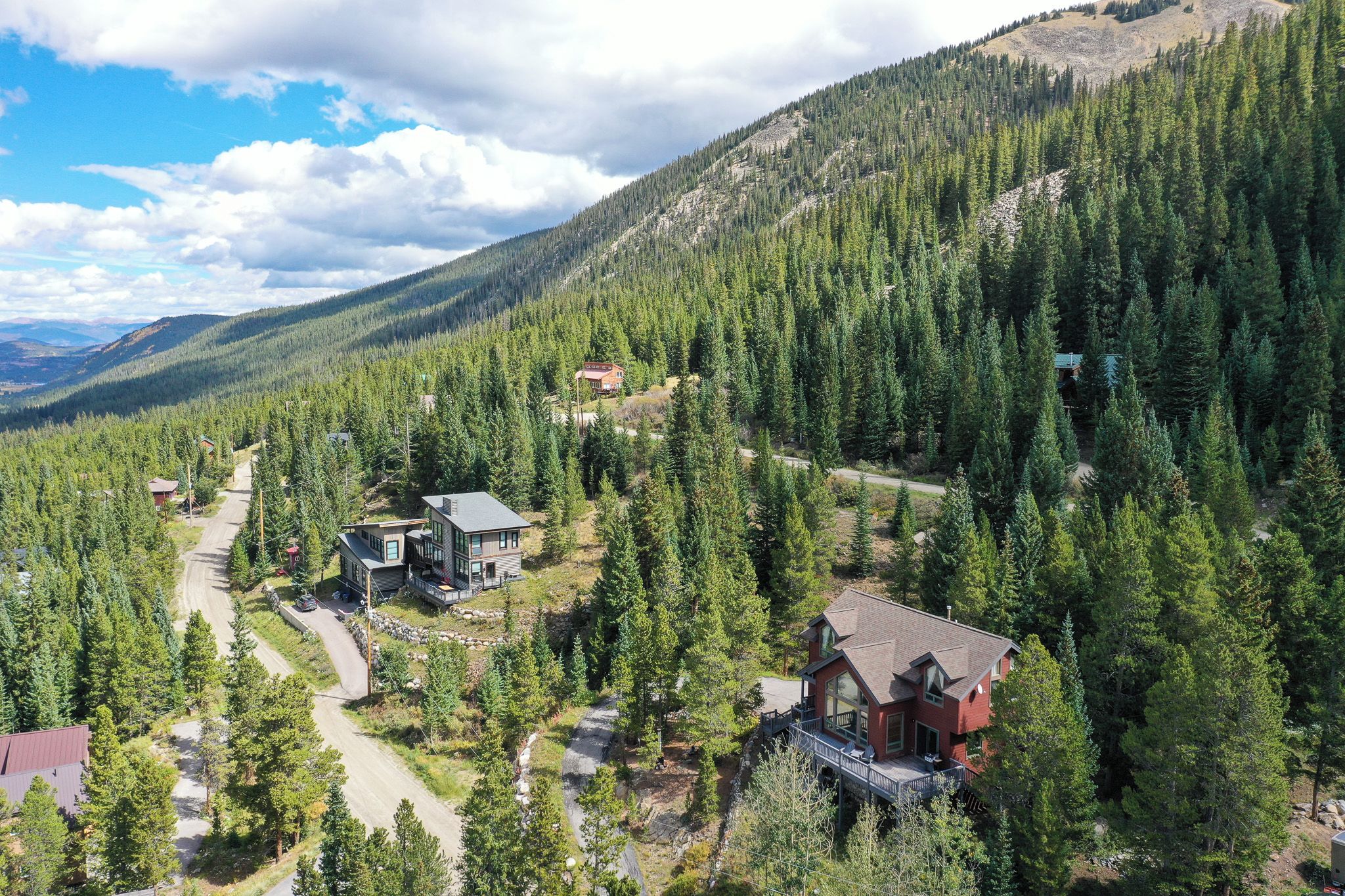 A mountainous area with multiple houses surrounded by dense forests.