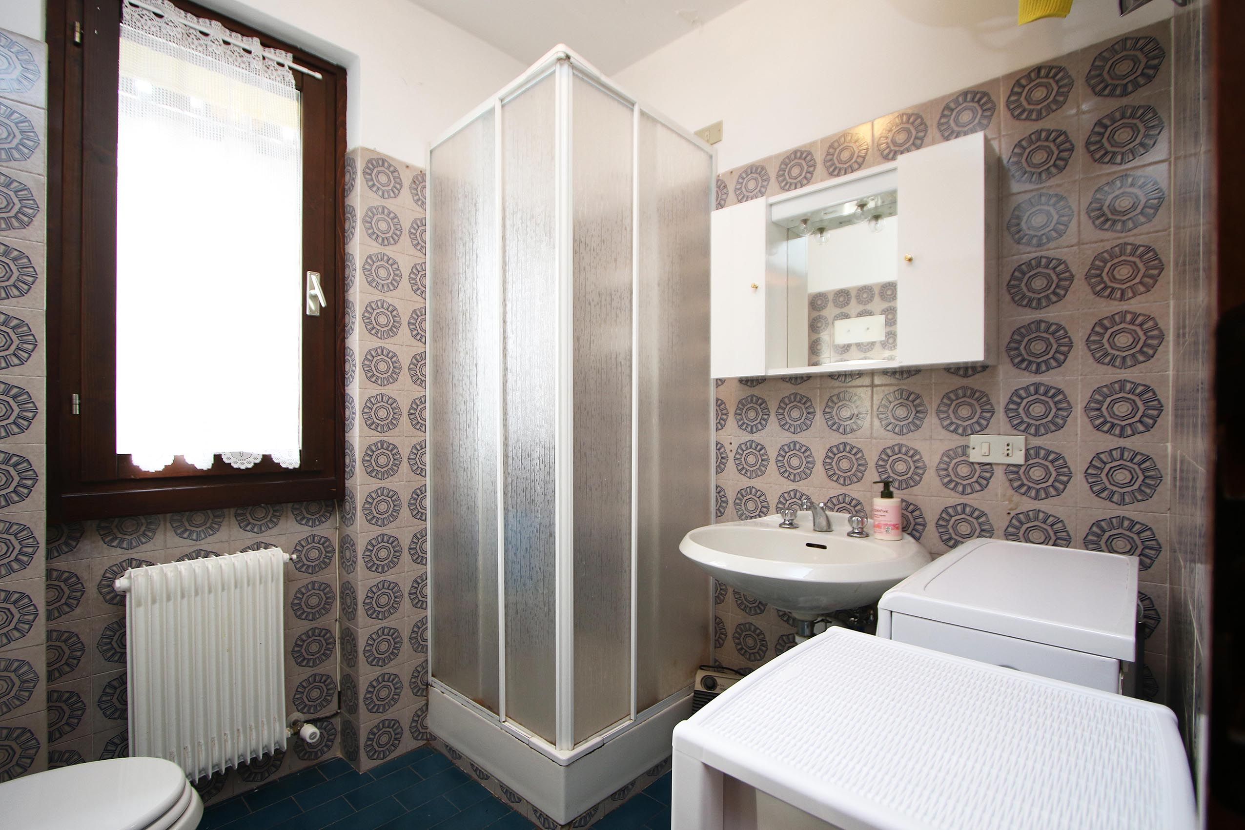 Une salle de bain équipée d’une douche, de toilettes, d’un lavabo et d’un miroir au-dessus du lavabo.