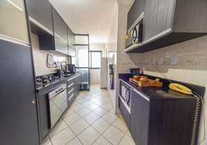 Une cuisine équipée d’une cuisinière à gaz, d’un four et d’un four à micro-ondes.