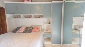 Ein Schlafzimmer mit einem Bett, Nachttischen und eingebauten Schränken.