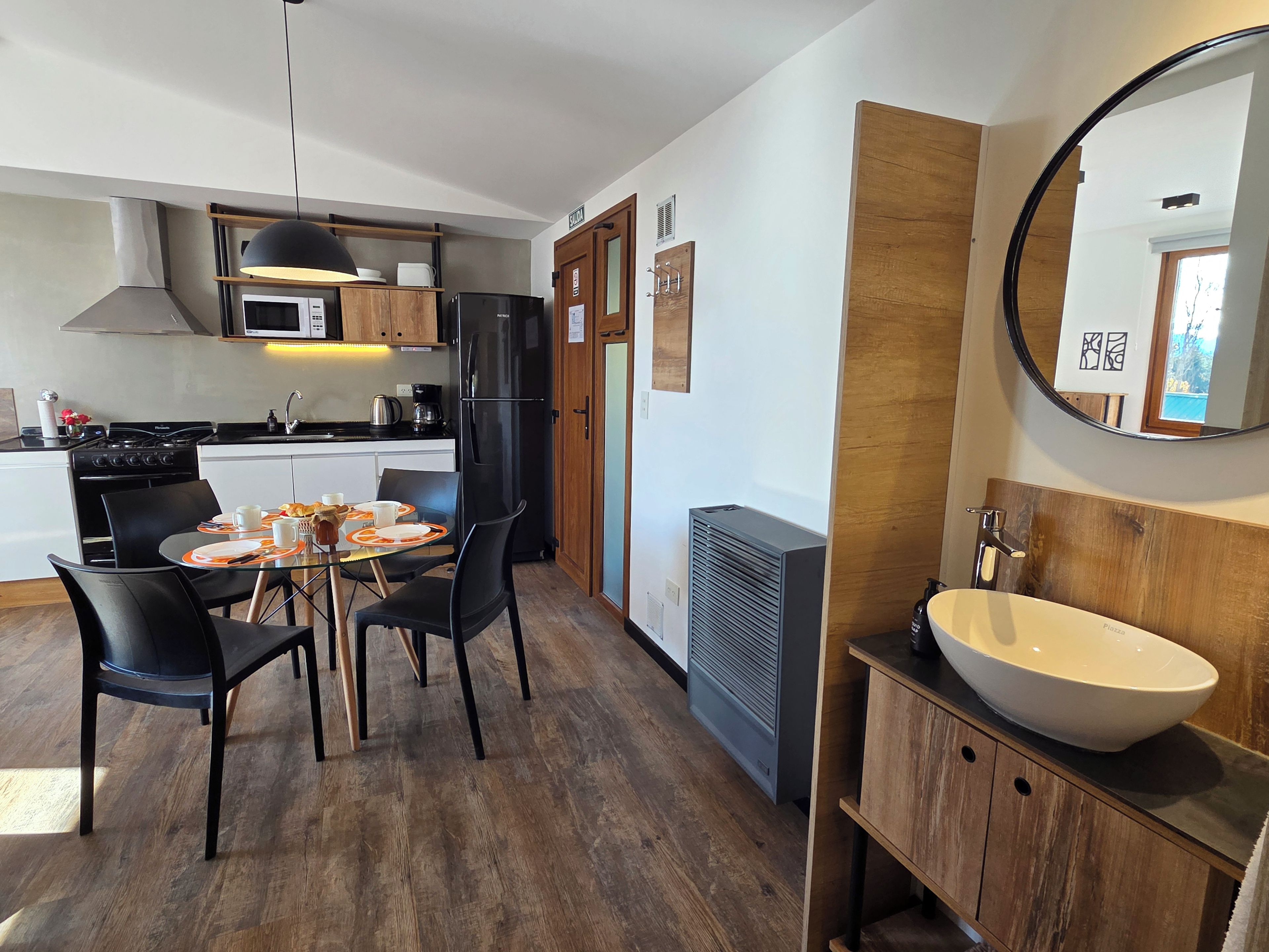 A modern kitchen with a dining area, a large mirror, and a built-in sink.