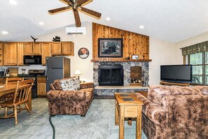 Ein Wohnzimmer mit Kamin, Holzmöbeln und einem Fernseher.
