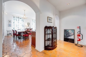 A dining area with a wooden table and chairs, a chandelier, and a fire extinguisher. - Spacious and comfortable apartment (Roma)