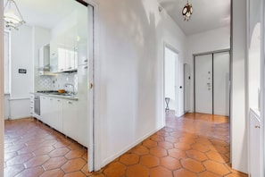 A modern kitchen with white cabinets, a gas stove, and a tiled backsplash. - Spacious and comfortable apartment (Roma)