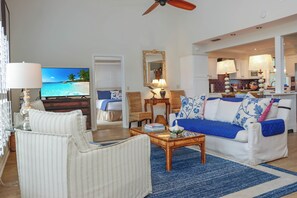 A living room with a television, sofa, chairs, and a coffee table. - 🌴Boardwalk Bungalow | Steps to Beach | Pool | Pet Friendly🌴 (Cape San Blas)