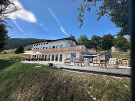 Un edificio con balcón, mobiliario exterior y vistas del paisaje circundante.