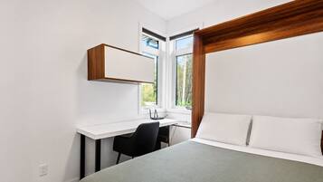 Une chambre à coucher avec un lit, un bureau et une chaise.