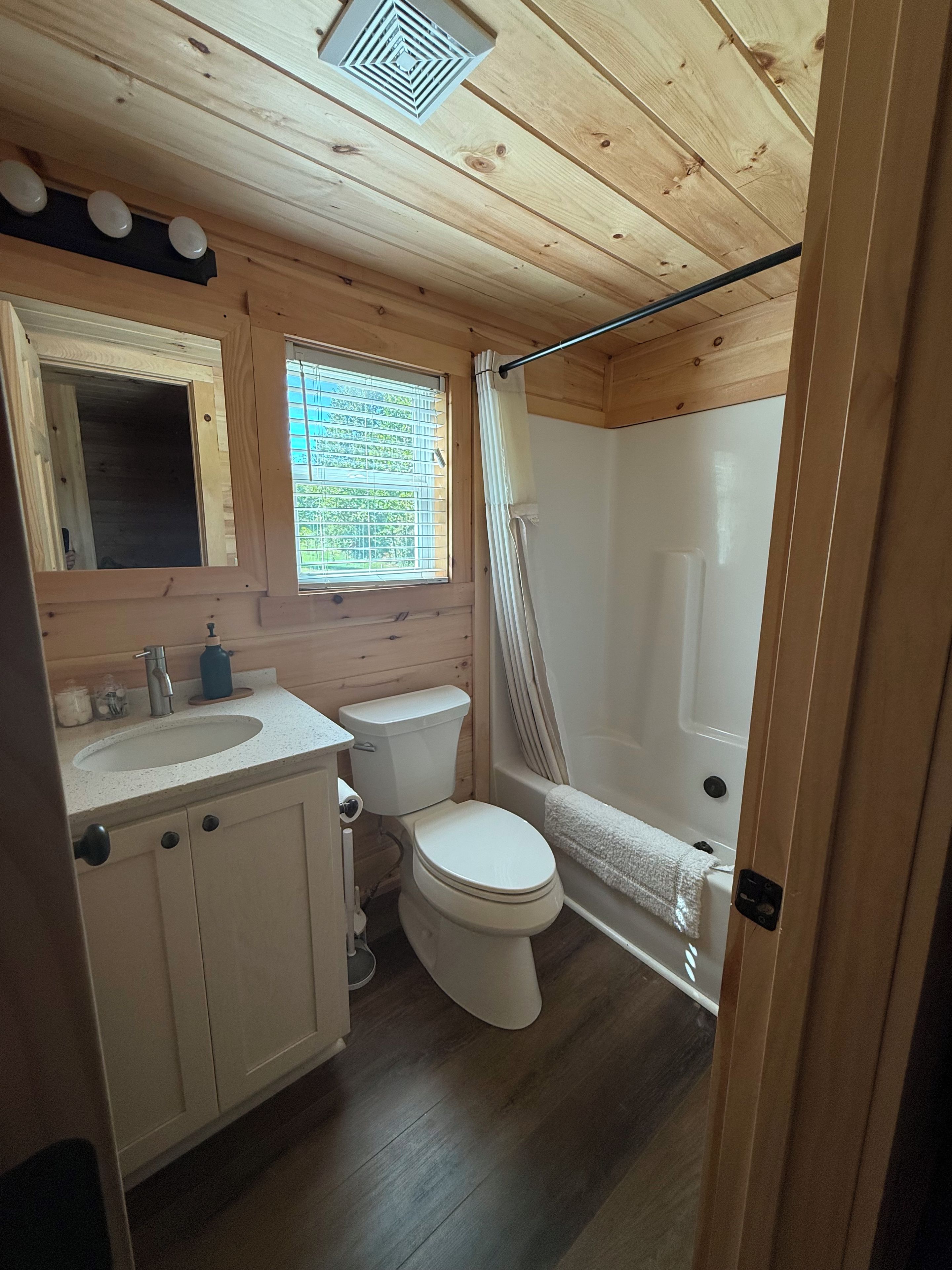 Un baño pequeño con inodoro, lavamanos y ducha.
