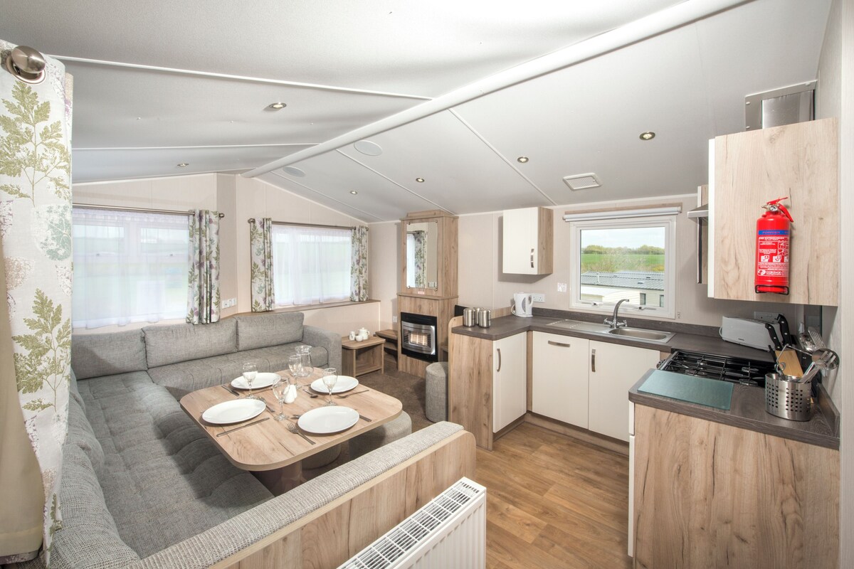 A compact kitchen with a dining area, a built-in stove, and a fire extinguisher.