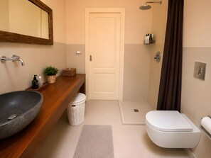 A bathroom with a wooden vanity, a large sink, a toilet, a shower, and a mirror. - Villa “Masseria Baba” with Private Pool, Wi-Fi, and Air Conditioning (Nardò)