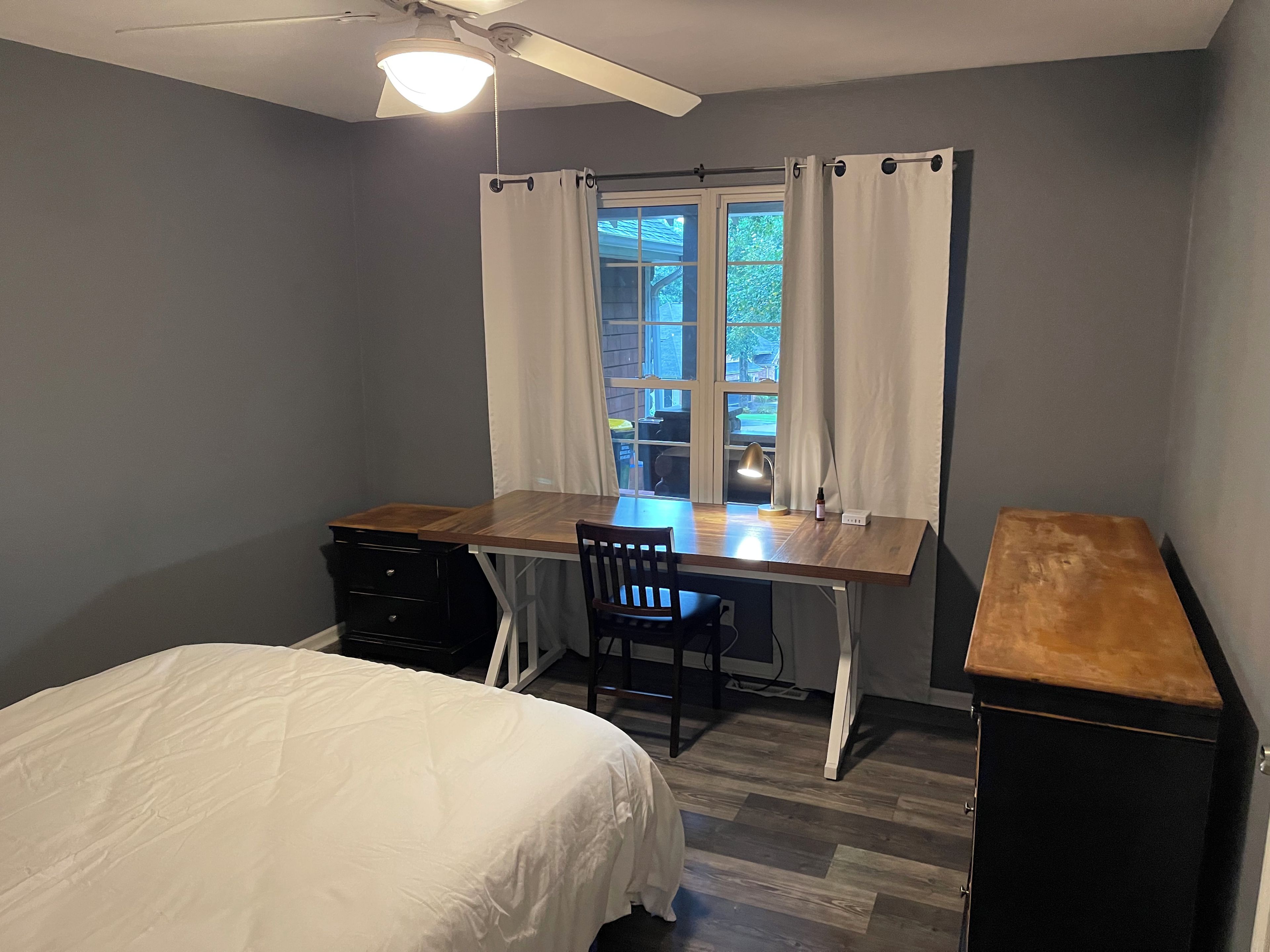 Un dormitorio con cama, escritorio y silla.