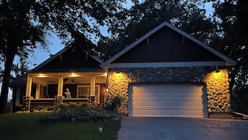 Une maison d’habitation avec une façade en pierre, un garage et une véranda.