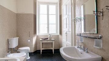 Ein Badezimmer mit Toilette, Bidet, Waschbecken und einem Fenster.