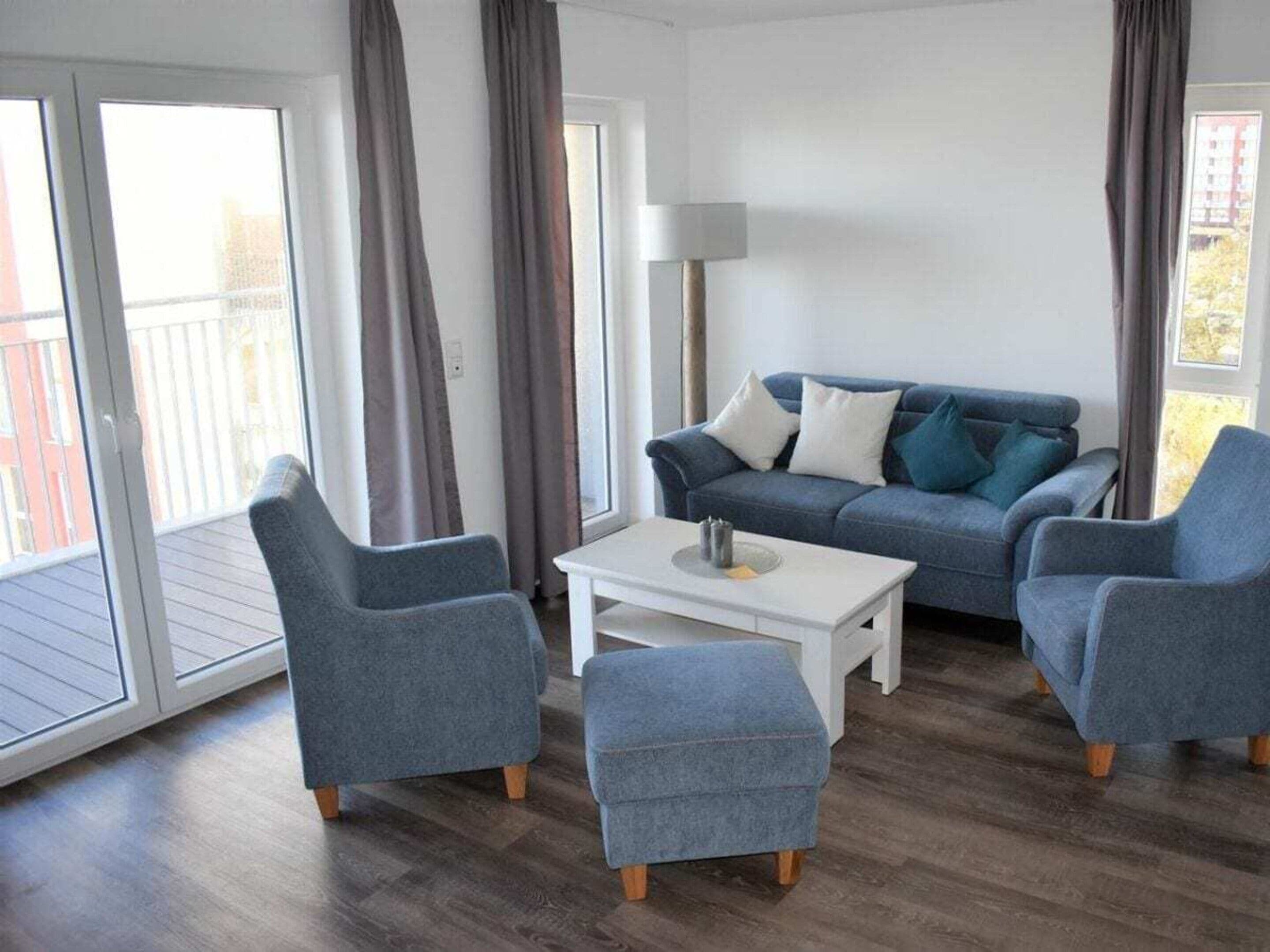 A living room with a sofa, two armchairs, a coffee table, and a lamp.
