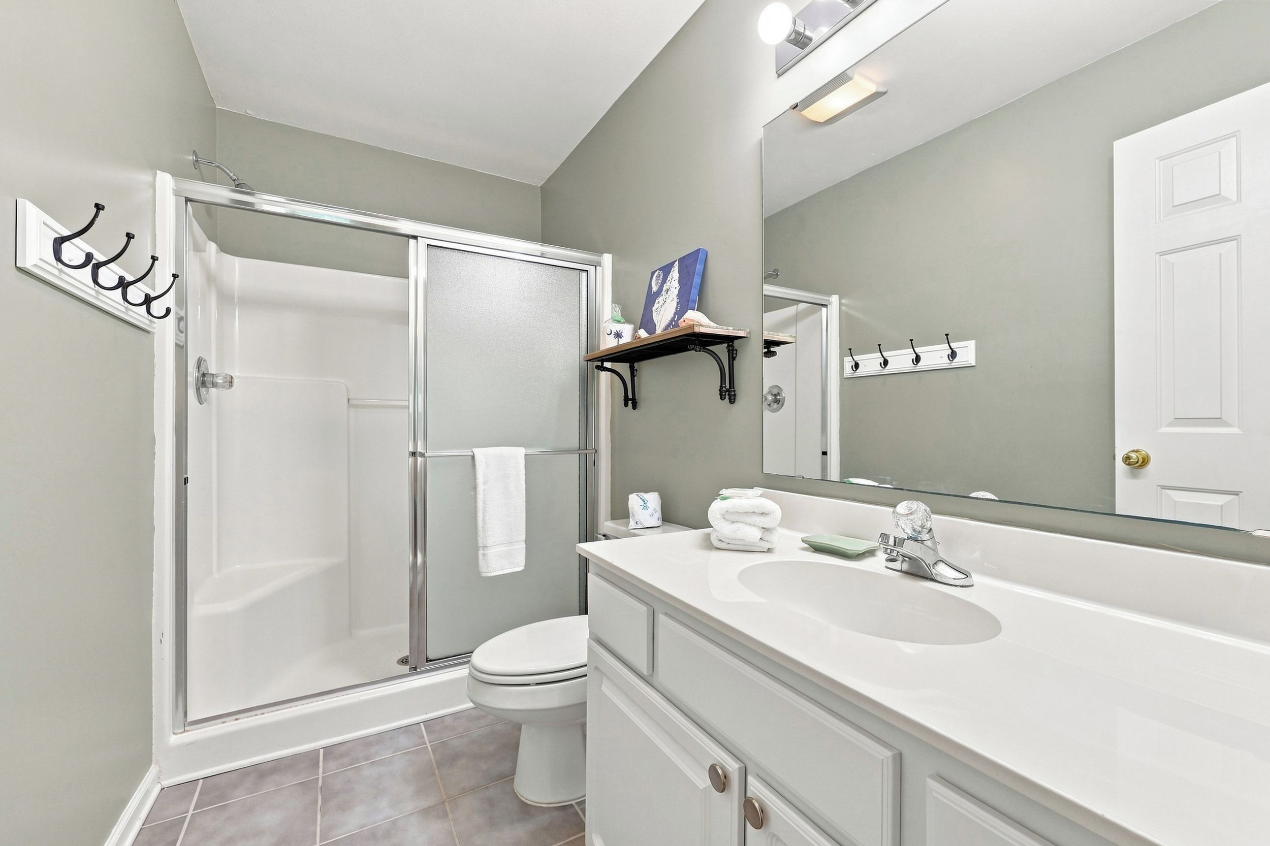 A bathroom with a shower, toilet, and sink.
