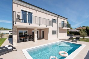 A two-story building with a swimming pool, outdoor seating, and a covered patio area. - Villa With Modern Living in Farini (Visnjan)