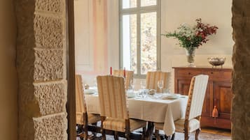 A dining area with a table set for four, surrounded by chairs with a patterned fabric.