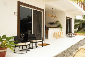 An outdoor seating area with a bar and a poolside view. - King Suite - Casa Corazon Zen in Barra De Potosi with pool, 3 min. walk to beach (Barra de Potosí)