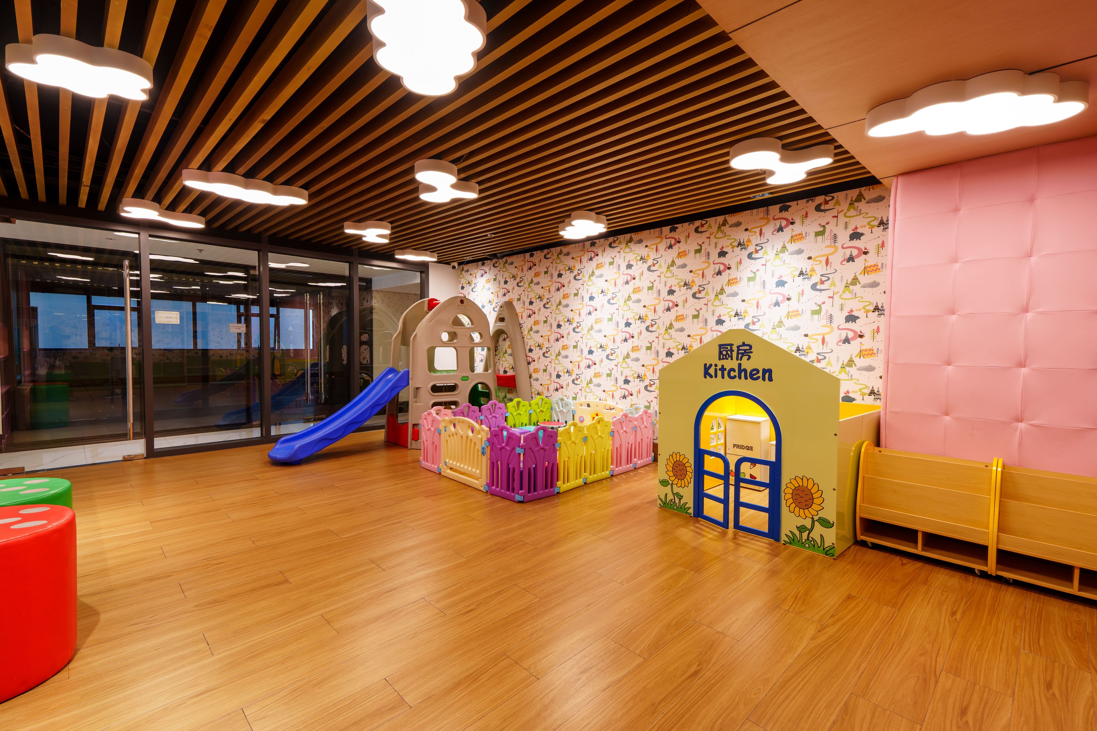 Ein Kinderspielbereich mit Rutsche, Spielzaun und einer Beschilderung für eine Küchenzeile.