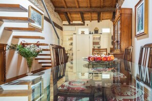 A dining area with a glass table, chairs, and a decorative centerpiece.