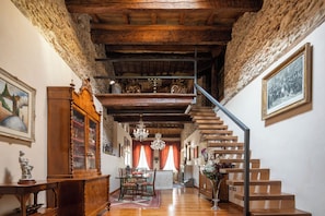 Un intérieur de style traditionnel avec un escalier en bois, un coin repas et un lustre.
