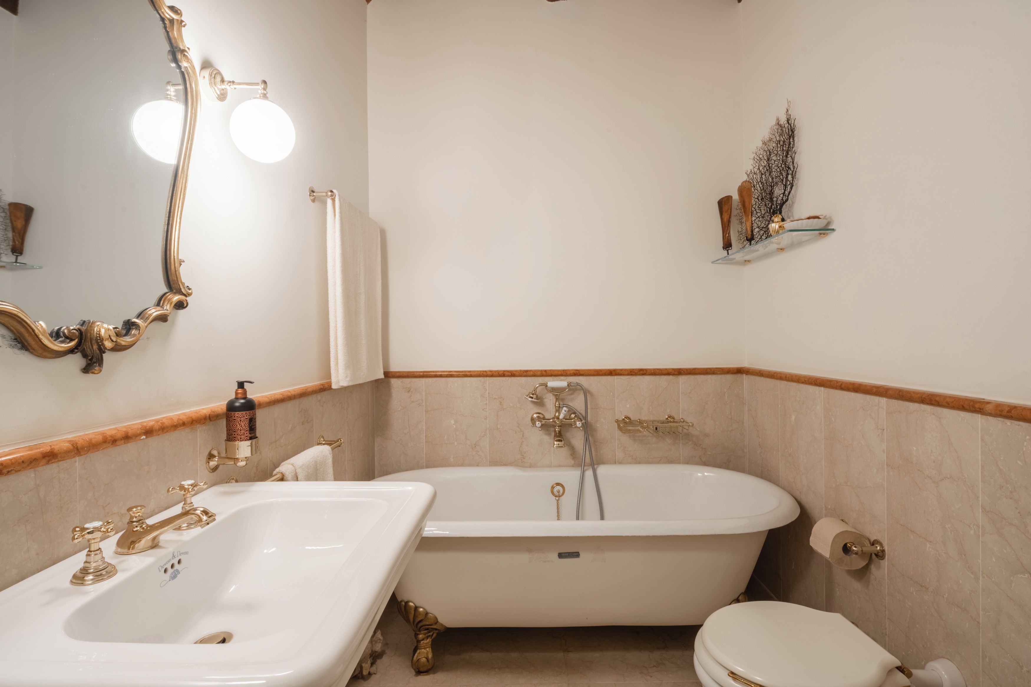 Een badkamer met een vrijstaand bad, een wastafel en een toilet.