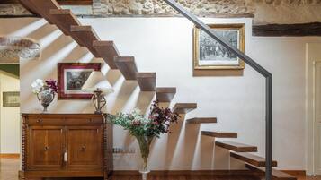 Una scala in legno con una parete in pietra e un quadro appeso al muro.
