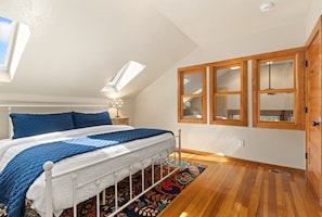 Sunlight streams through skylights onto your cozy retreat, where warm wood tones and charming architectural details create a peaceful sanctuary for restful nights. - The Sanctuary | Old Town Retreat & Garden Oasis (Fort Collins)