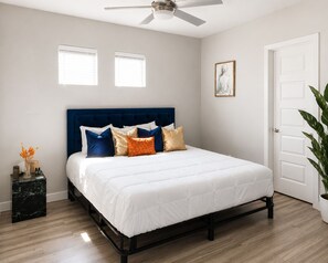 A bedroom with a bed, a ceiling fan, a door, and a window. - Spa-Inspired Escape Cozy 2BR/2BA with Private Yard in Fort Worth (Fort Worth)