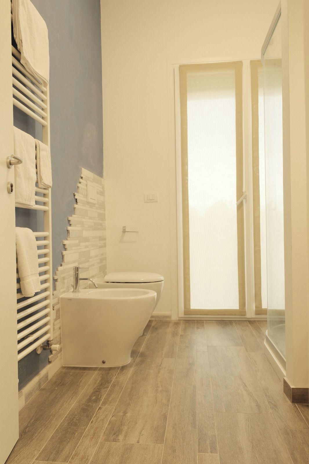 Een badkamer met toilet, wastafel en handdoekrek.