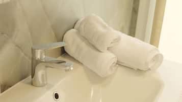 A bathroom with a sink, a towel rack, and a mirror.
