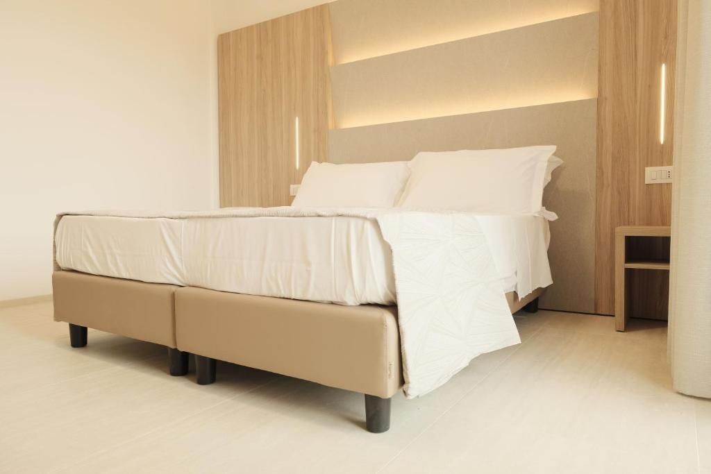 Un dormitorio moderno con cama, cabecero de madera y mesita de noche.