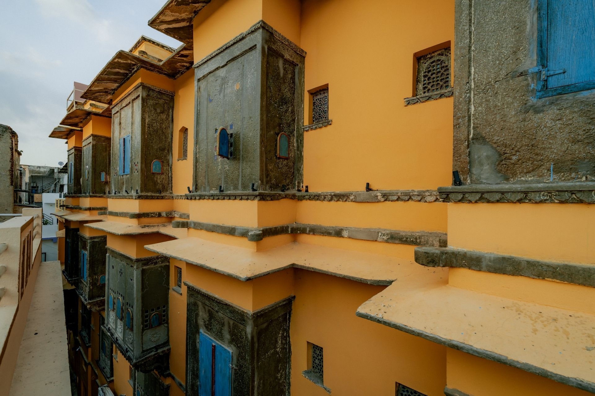 Een rij traditionele gebouwen met balkons en blauwe deuren.