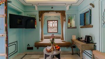 Una habitación de diseño tradicional, con una ventana con cortinas, una mesa con un florero y una zona de café.